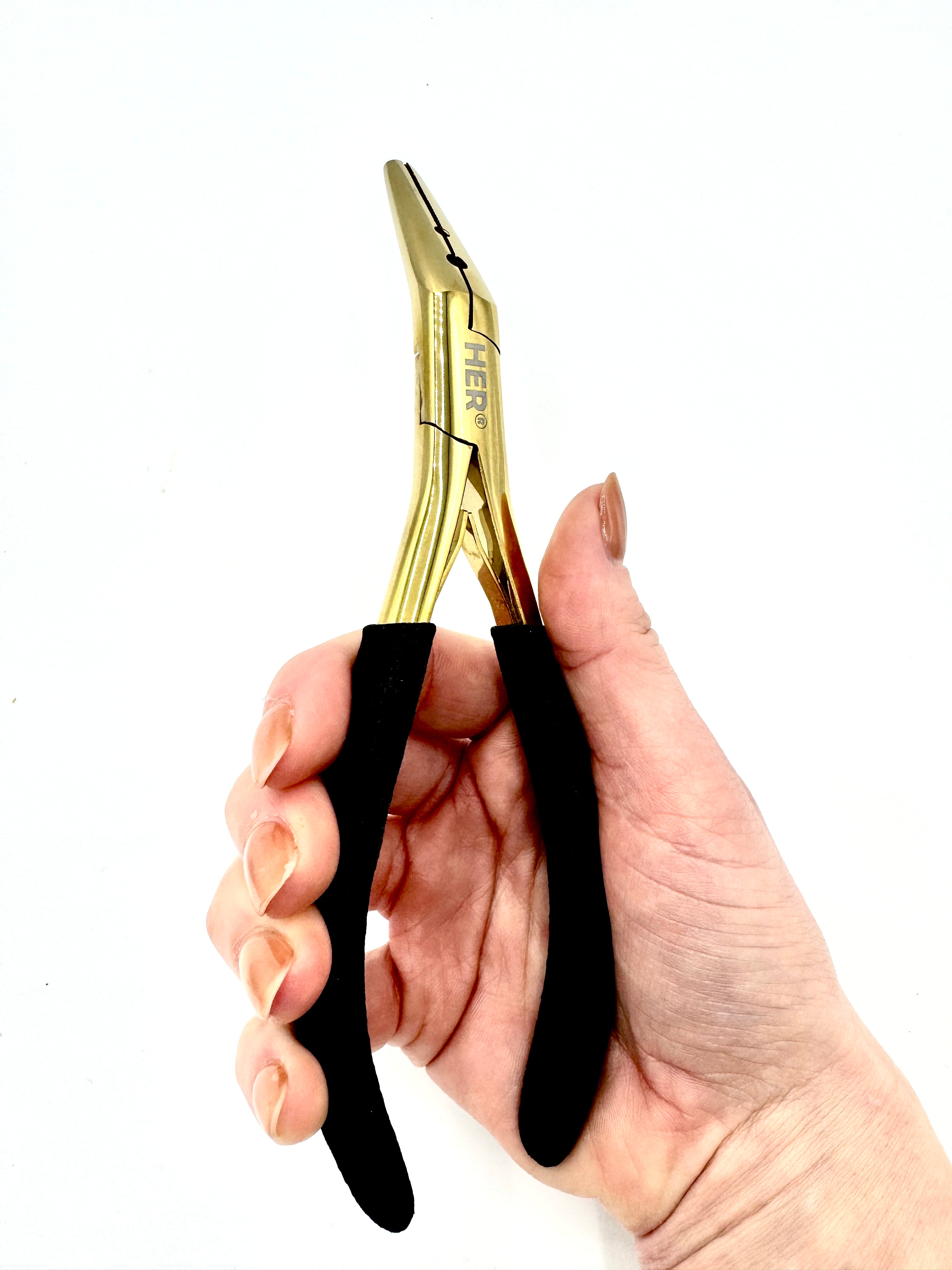 Hand holding a pair of gold pliers with black handles on a white background